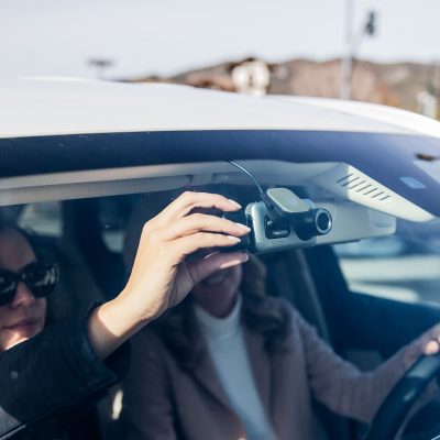 two women in car adjusting dash cam